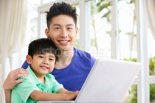 Chinese Father And Son Sitting At Desk Using Laptop At Home Stock photo © monkey_business