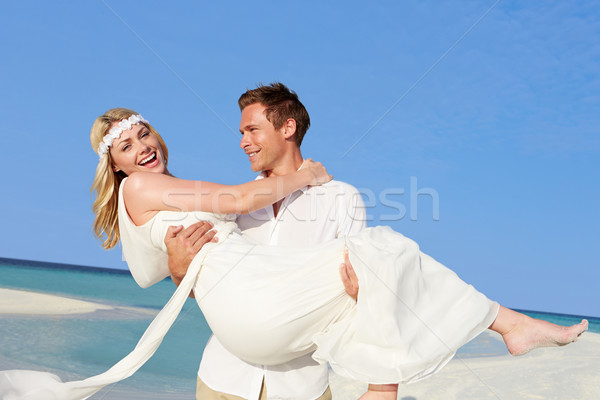 Groom Carrying Bride At Beautiful Beach Wedding Stock photo © monkey_business