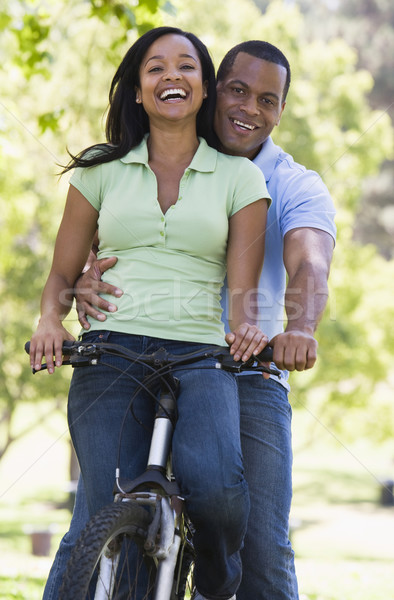 Stock photo: Couple on a bike outdoors smiling