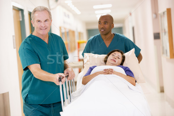 Two Orderlies Pushing A Woman In A Bed Down A Hospital Corridor Stock photo © monkey_business