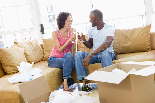 Couple toasting champagne by boxes in new home smiling Stock photo © monkey_business