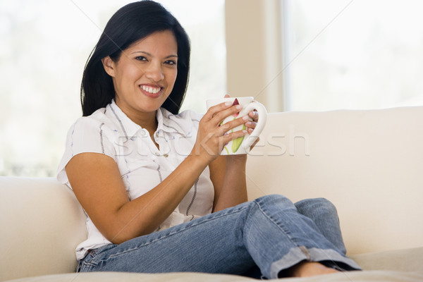 Stock photo: Woman in living room with coffee smiling