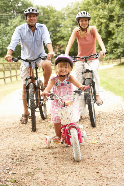 Family Cycling In Countryside Wearing Safety Helmets Stock photo © monkey_business