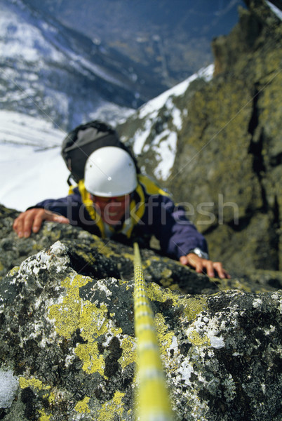Mountaineer scaling snowy rock face Stock photo © monkey_business