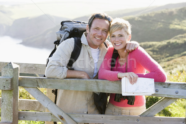 Couple on cliffside outdoors leaning on railing and smiling Stock photo © monkey_business