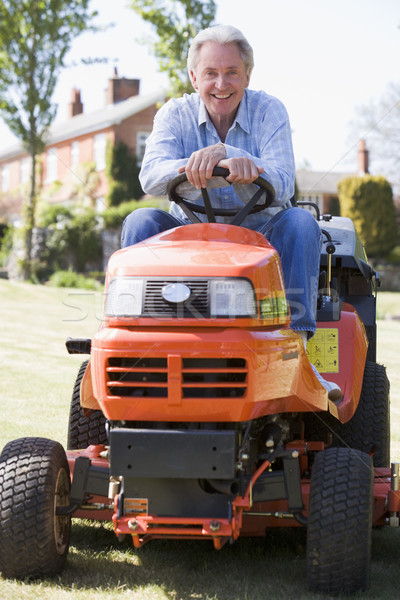 Man outdoors on lawnmower smiling Stock photo © monkey_business