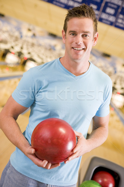 Young man holding a bowling ball in a bowling alley Stock photo © monkey_business