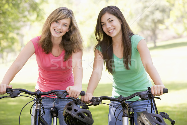 Boldog barátok tinédzser park mosolyog biciklizik Stock fotó © monkey_business