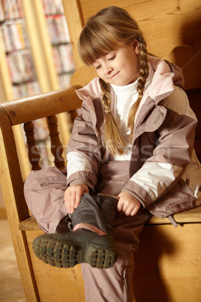 Young Girl Sitting On Wooden Seat Putting On Warm Outdoor Clothe Stock photo © monkey_business