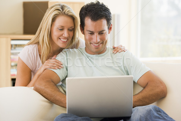 Couple in living room using laptop smiling Stock photo © monkey_business