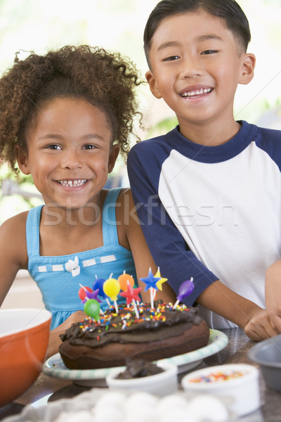 Two children in kitchen with birthday cake smiling Stock photo © monkey_business