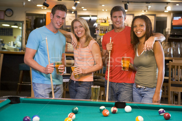 Two young couples standing beside a pool table in a bar Stock photo © monkey_business