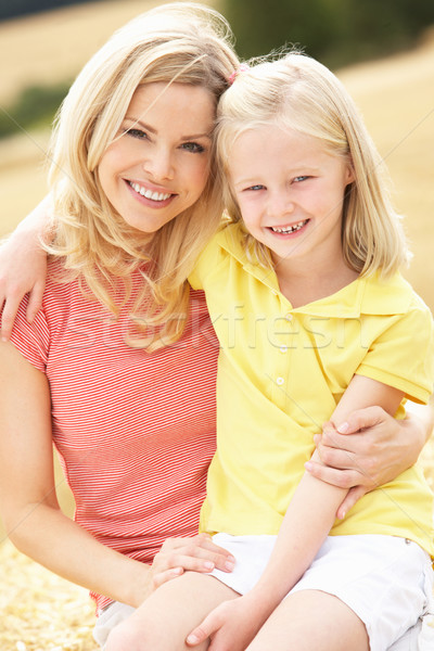Mother And Daughter Sitting On Straw Bales In Harvested Field Stock photo © monkey_business