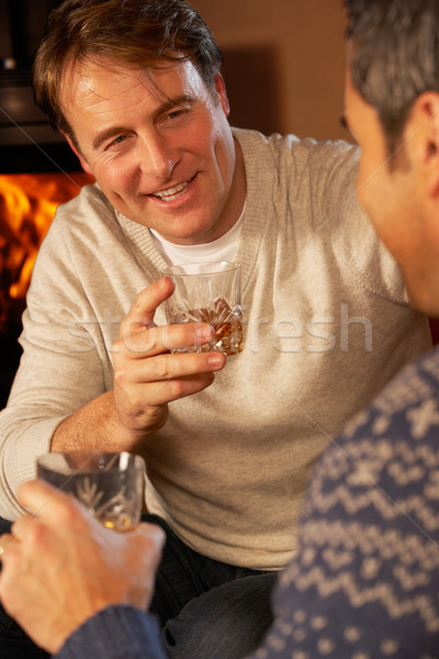 Stock photo: Two Middle Aged Men Relaxing Sitting On Sofa Drinking Whisky