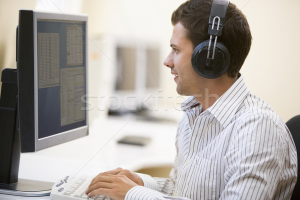 Adam kulaklık bilgisayar odası yazarak gülen Stok fotoğraf © monkey_business
