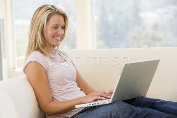 Сток-фото: женщину · гостиной · используя · ноутбук · улыбающаяся · женщина · улыбаясь · компьютер