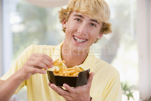 Mananca franceza cartofi prajiti acasă băiat adolescent Imagine de stoc © monkey_business