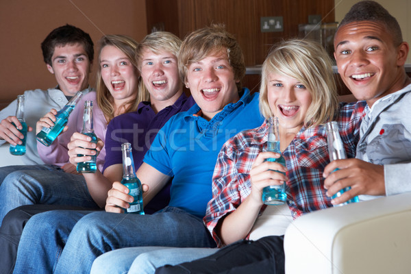 Group Of Teenage Friends Sitting On Sofa At Home Watching Drinki Stock photo © monkey_business
