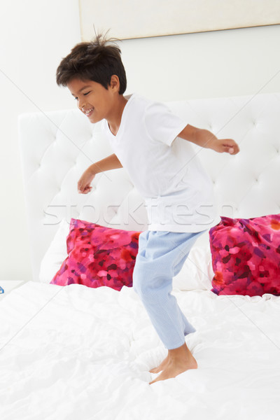 Boy Jumping On Bed Wearing Pajamas Stock photo © monkey_business