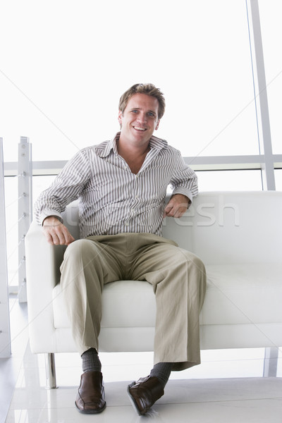 Businessman sitting in office lobby smiling Stock photo © monkey_business