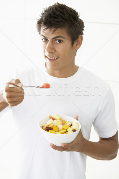 Fiatalember eszik friss gyümölcs saláta étel férfi Stock fotó © monkey_business