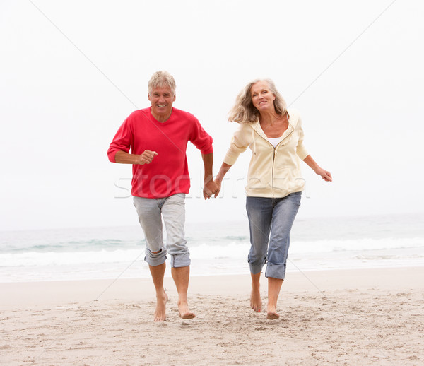 Senior Couple On Holiday Running Along Winter Beach Stock photo © monkey_business