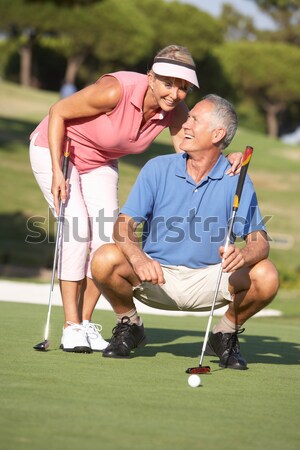 Couple Golfing On Golf Course Lining Up Putt On Green Stock photo © monkey_business