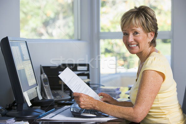 Stock photo: Woman in home office with computer and paperwork smiling
