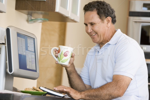 Człowiek kuchnia komputera kawy uśmiechnięty biurko Zdjęcia stock © monkey_business