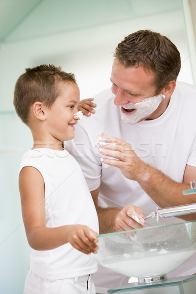 Man in bathroom putting shaving cream on young boy's nose Stock photo © monkey_business