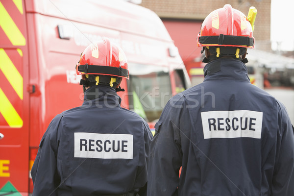 Firefighters standing by a small fire engine Stock photo © monkey_business