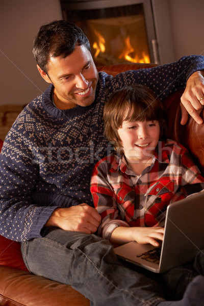 Stock photo: Father And Son Using Laptop Computer By Cosy Log Fire