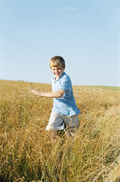 Fiatal srác fut kint mosolyog fű mező Stock fotó © monkey_business