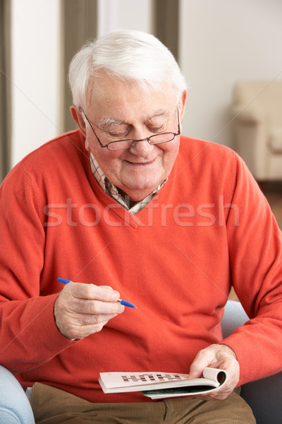 Senior Man Relaxing In Chair At Home Completing Crossword Stock photo © monkey_business