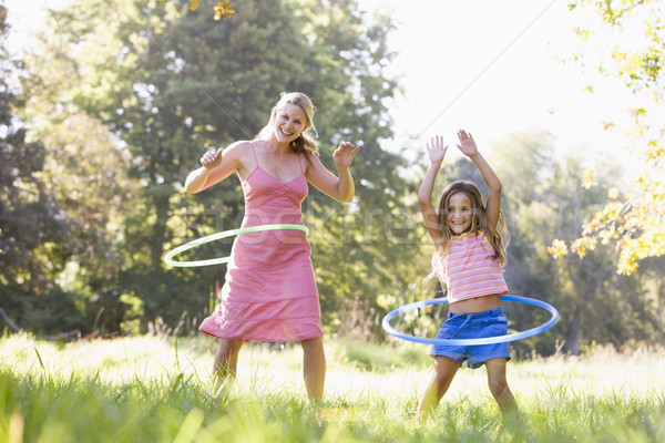 Woman and young girl with hula hoops outdoors smiling Stock photo © monkey_business