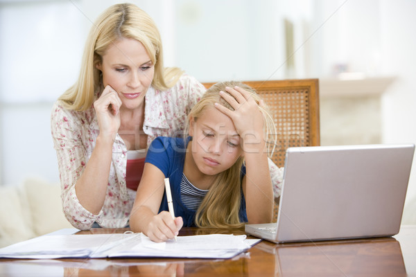 Woman helping young girl with laptop do homework in dining room Stock photo © monkey_business