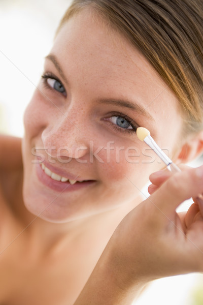 Woman with eyeshadow applicator smiling Stock photo © monkey_business