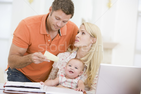 Couple and baby in dining room with laptop and paperwork Stock photo © monkey_business