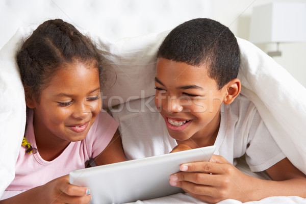 Two Children Using Digital Tablet Under Duvet Stock photo © monkey_business