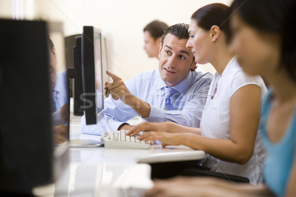 Man assisting woman in computer room Stock photo © monkey_business