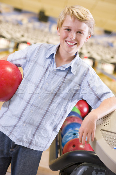 Young boy in bowling alley holding ball and smiling Stock photo © monkey_business