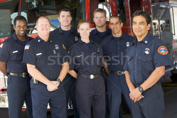 Stock photo: Portrait of firefighters standing by a fire engine