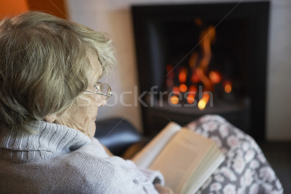 Senior Woman Reading Book By Fire At Home Stock photo © monkey_business