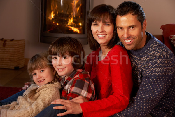 Portrait Of Family Relaxing On Sofa By Cosy Log Fire Stock photo © monkey_business