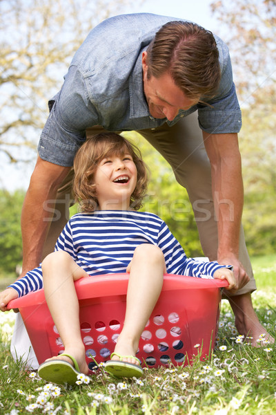 Father Carrying Son Sitting In Laundry Basket Stock photo © monkey_business