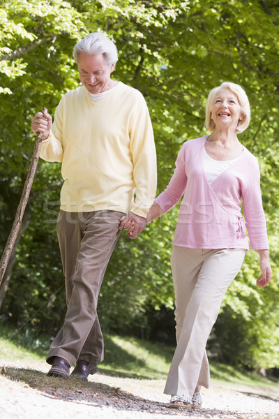 Couple walking on path in park holding hands and smiling Stock photo © monkey_business