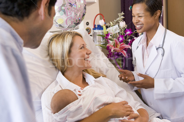 New parents with baby talking to doctor and smiling Stock photo © monkey_business