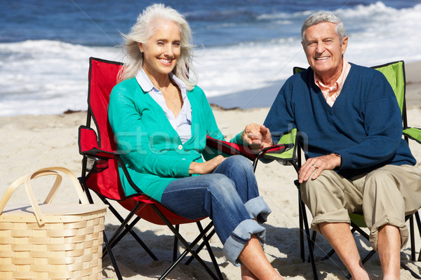 Senior Couple Sitting On Beach In Deckchairs Having Picnic Stock photo © monkey_business