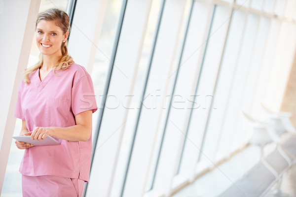 Stock photo: Nurse Using Digital Tablet In Corridor Of Modern Hospital