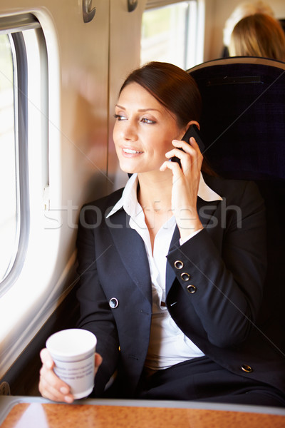 Female Commuter With Coffee On Train Using Mobile Phone Stock photo © monkey_business